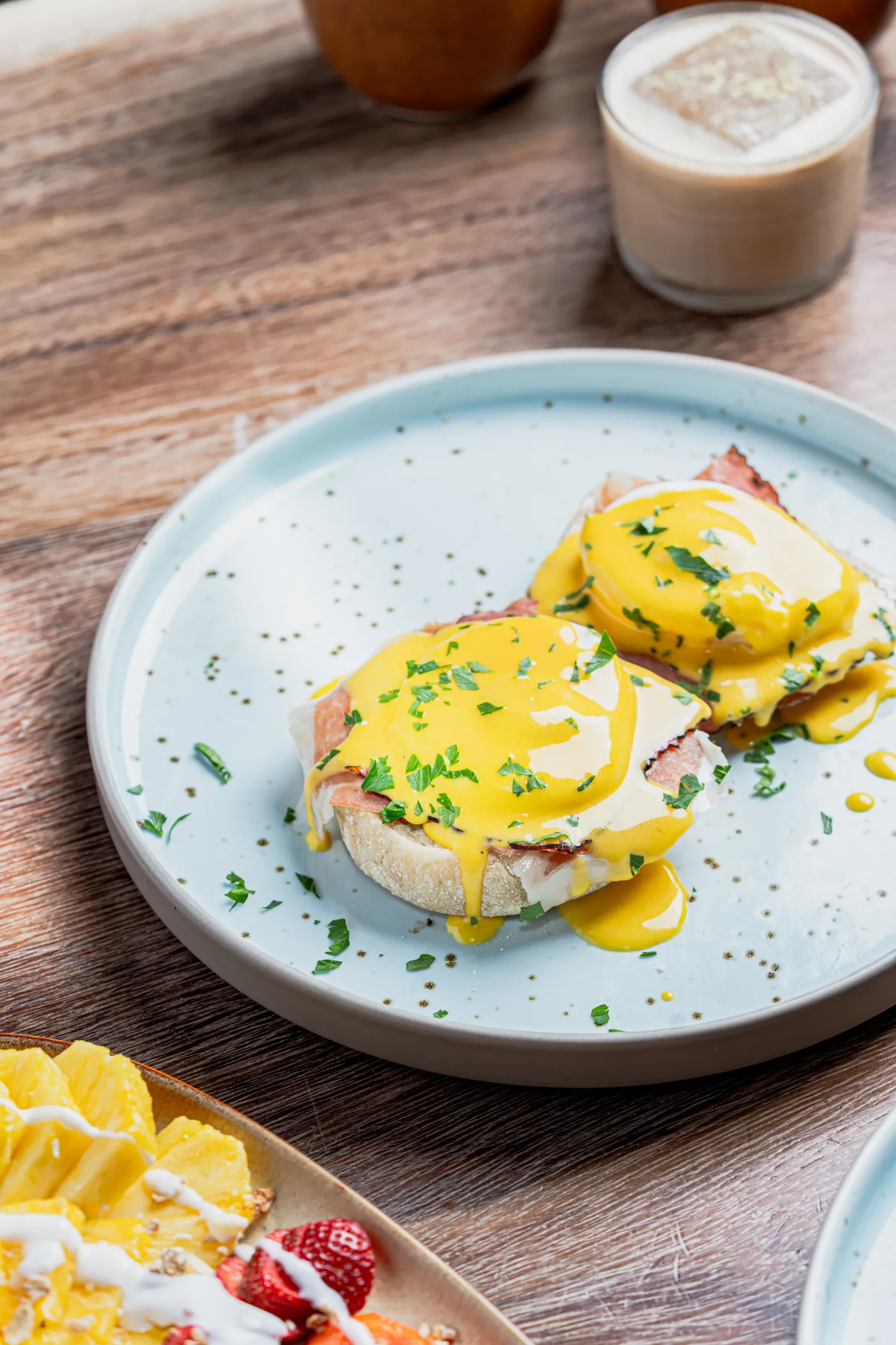 Huevos benedictinos con salsa holandesa en un plato azul claro