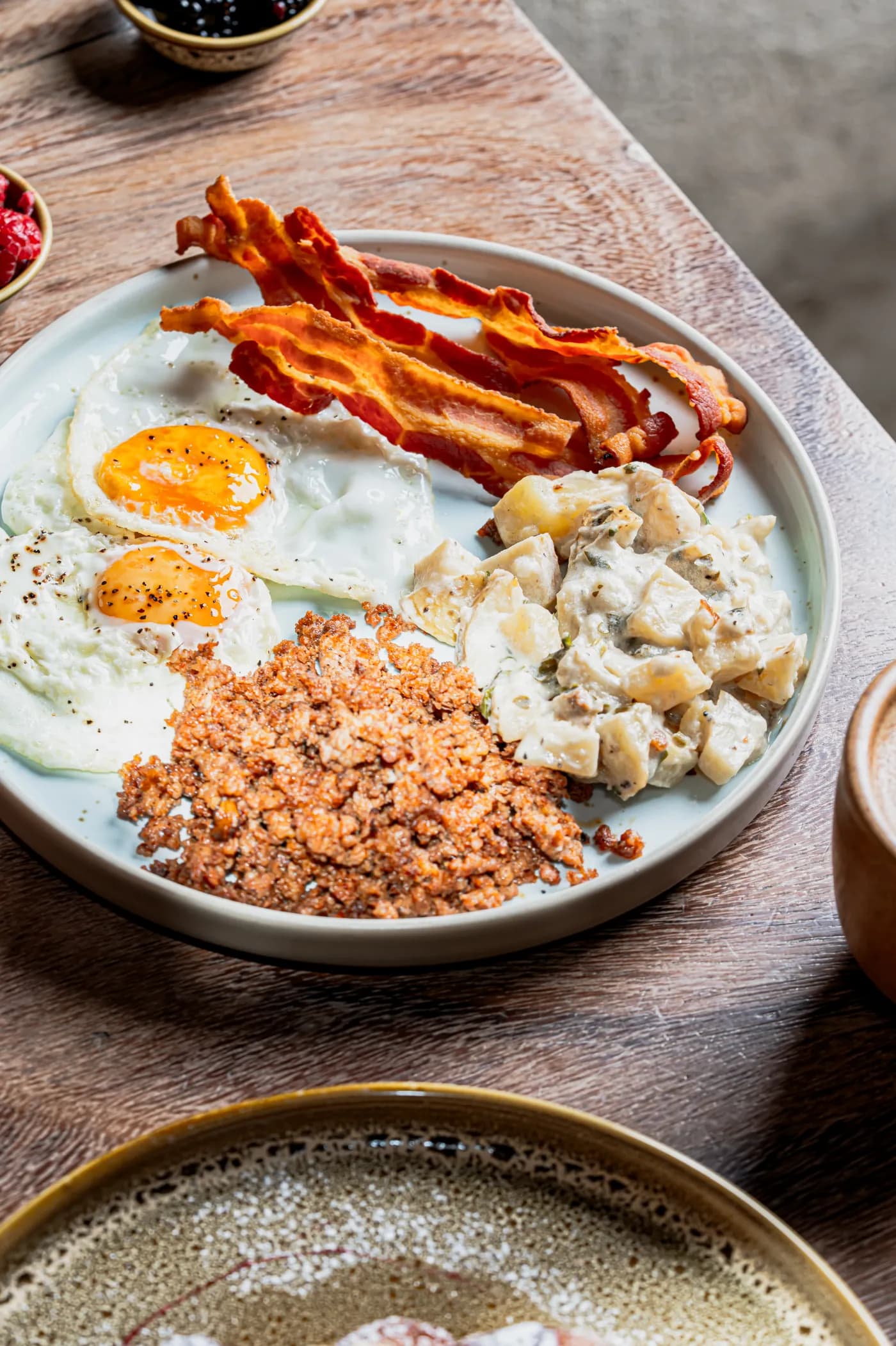 Desayuno con huevos estrellados, tocino, carne deshebrada y papas