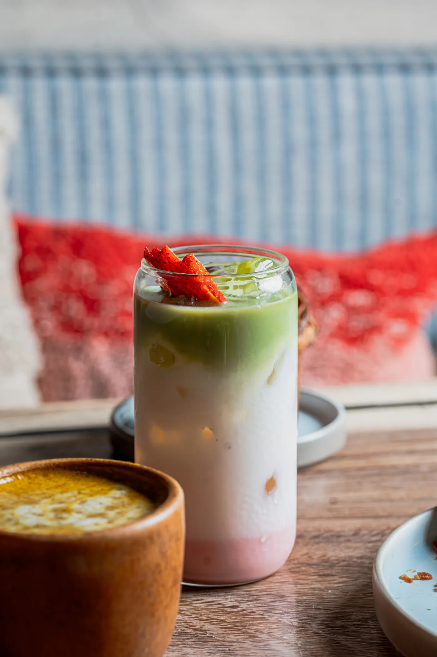 Bebida fría en capas verde y rosa servida en un vaso de vidrio