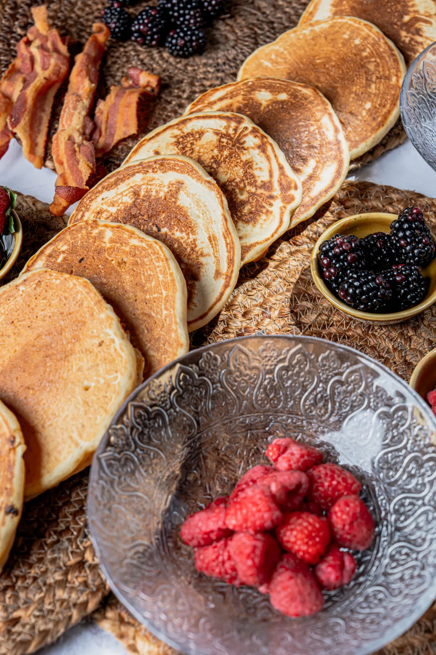 Hot cakes apilados con tocino, zarzamoras y frambuesas